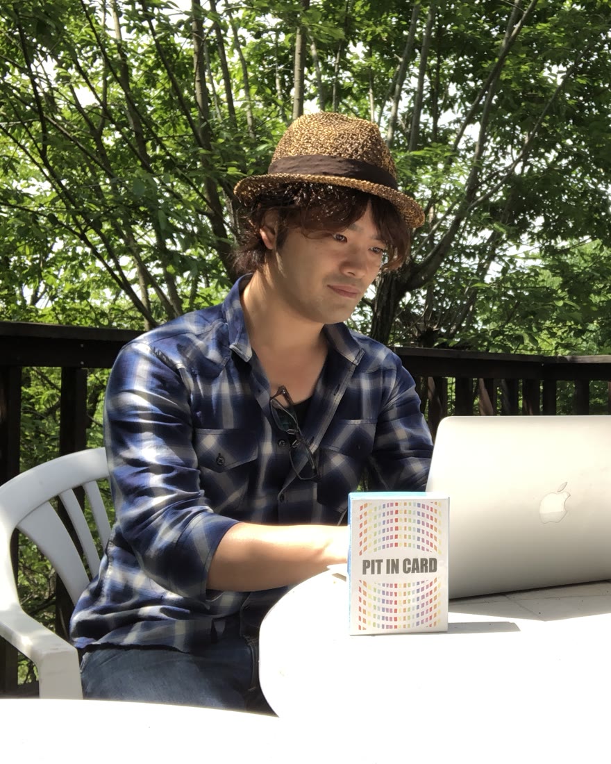 屋外のテーブルでMacBookに向かうじゅんコーチ